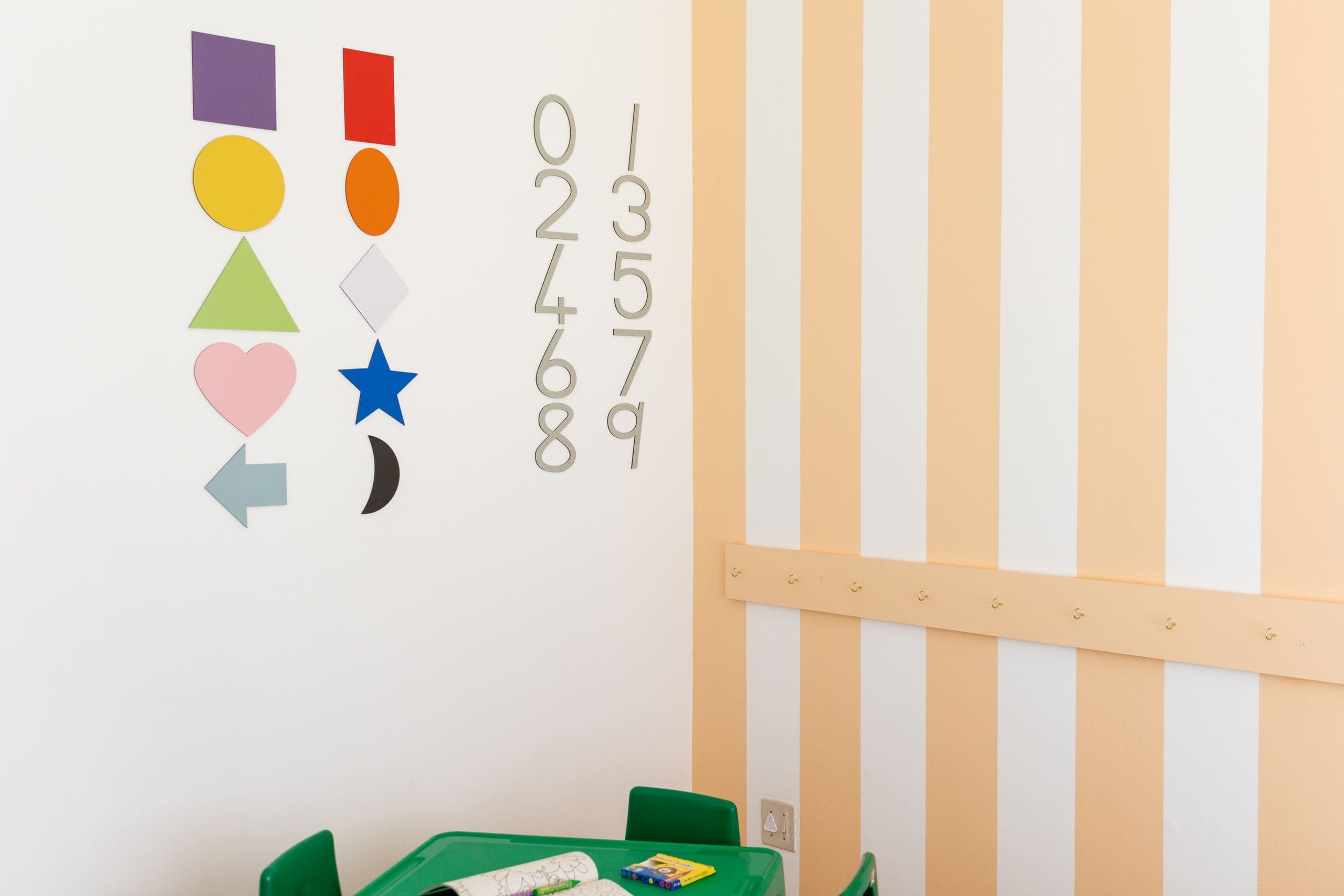 Wall-mounted shape cut-outs and number decorations in a classroom